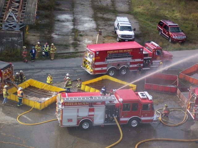 A group of firefighters are spraying water on a fire