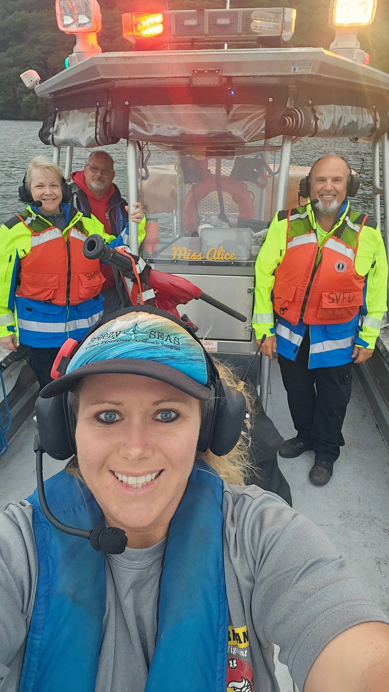 A woman is taking a selfie with a group of people on a boat.