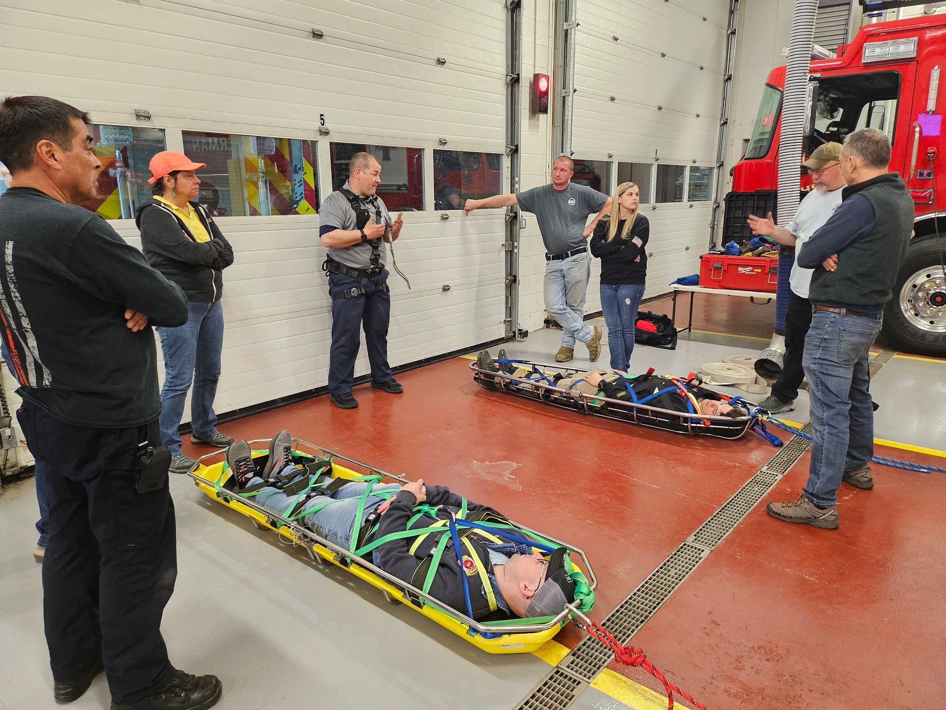 A group of men are standing around a stretcher with a man laying on it.