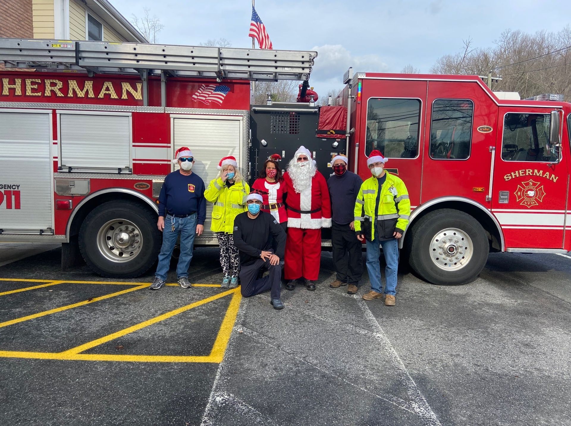 A group of people are posing for a picture in front of a fire truck.