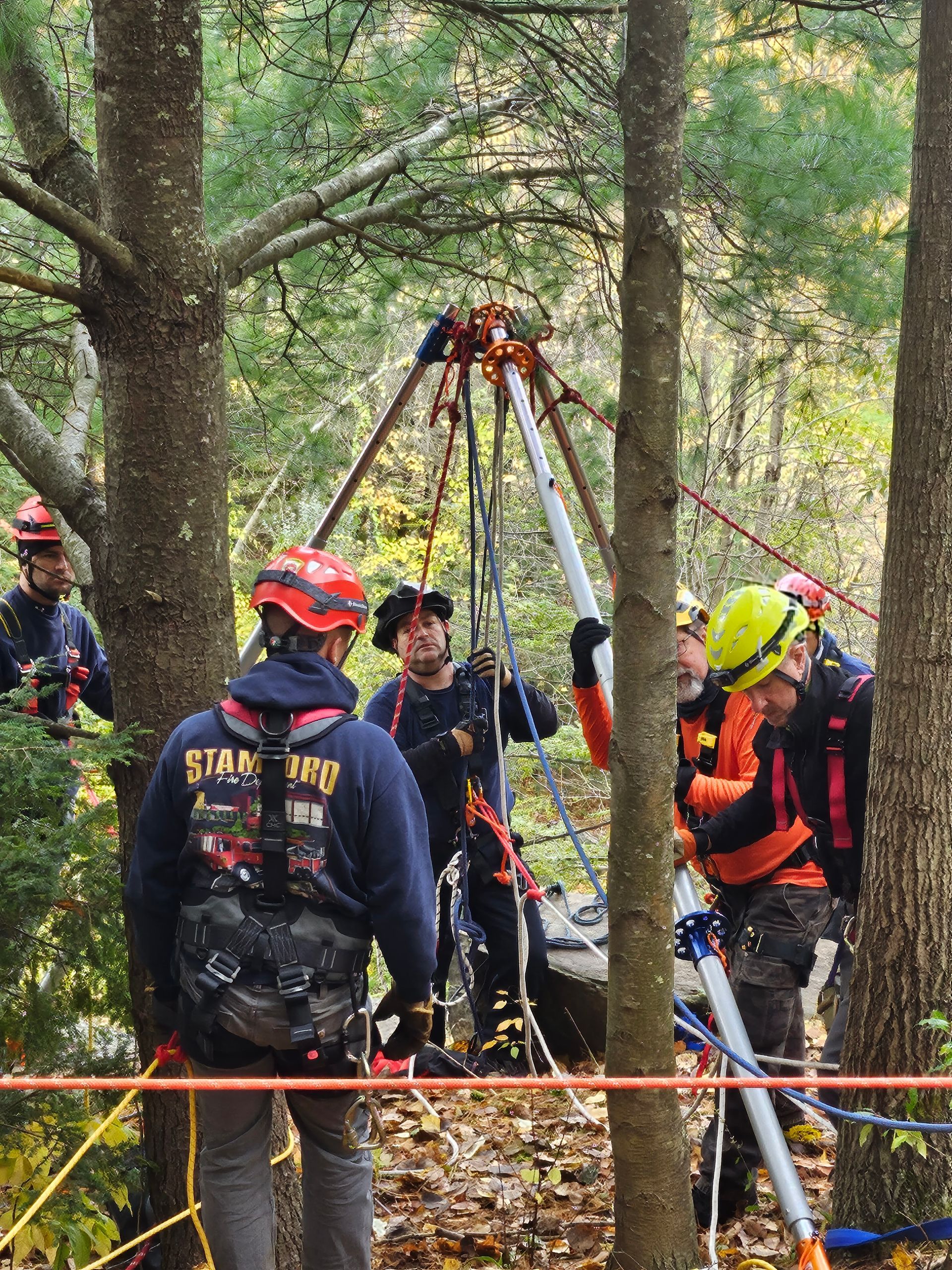 A group of men are standing in the woods and one of them is wearing a shirt that says star trek