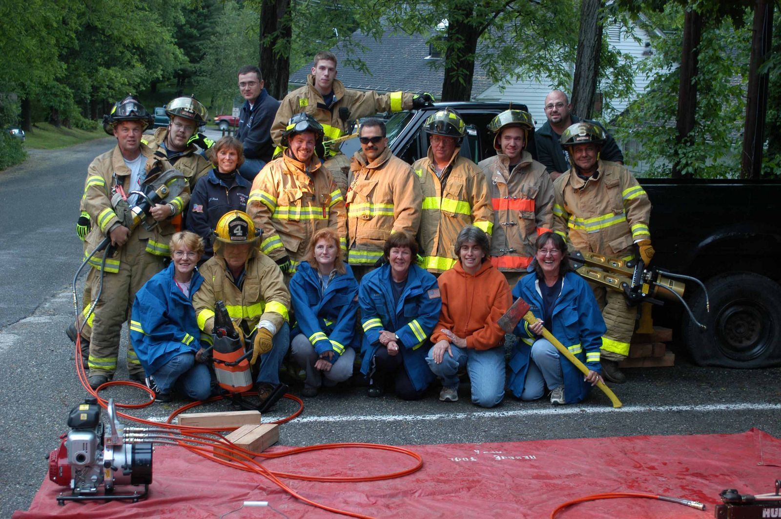 A group of firefighters posing for a picture in front of a truck