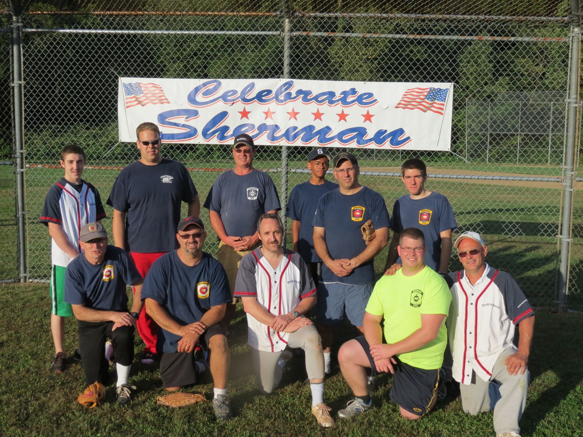 A group of men are posing for a picture in front of a banner that says celebrate sherman