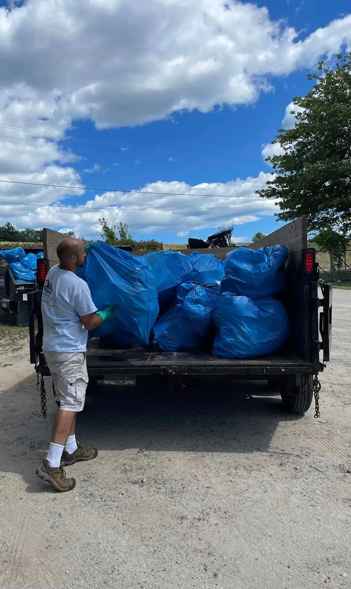A man is loading bags into the back of a truck.