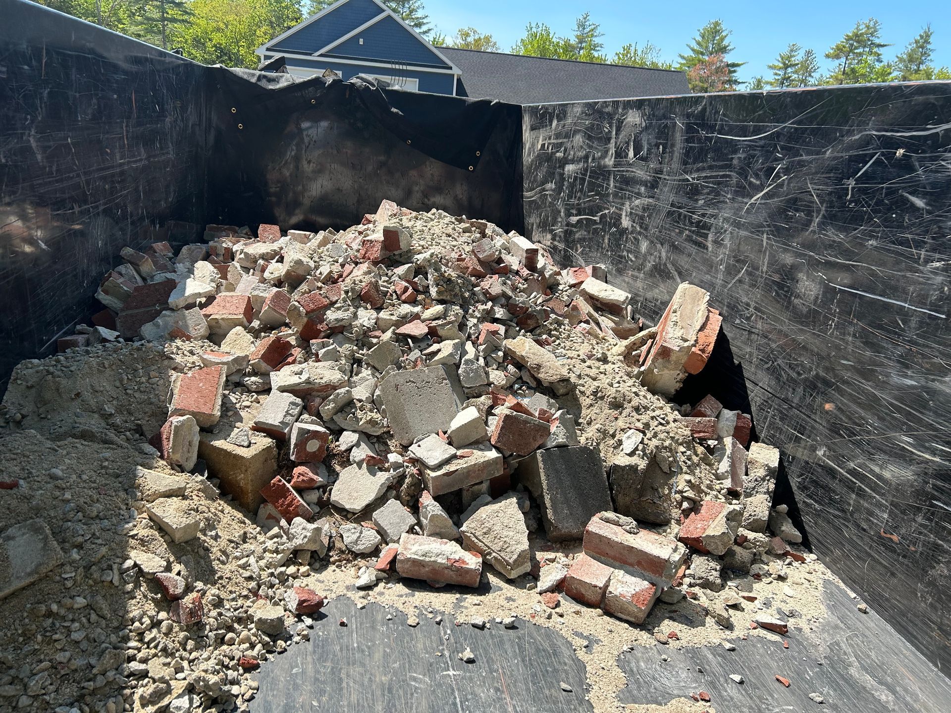 A pile of bricks and rocks in a dumpster.