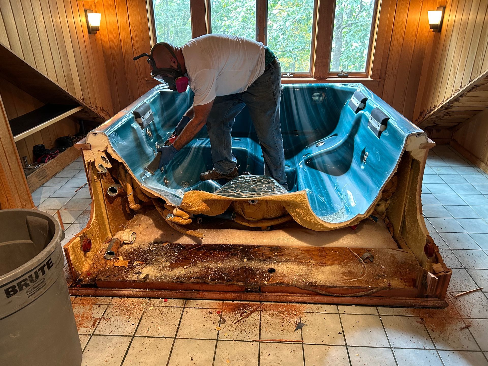 A man is working on a hot tub in a room.