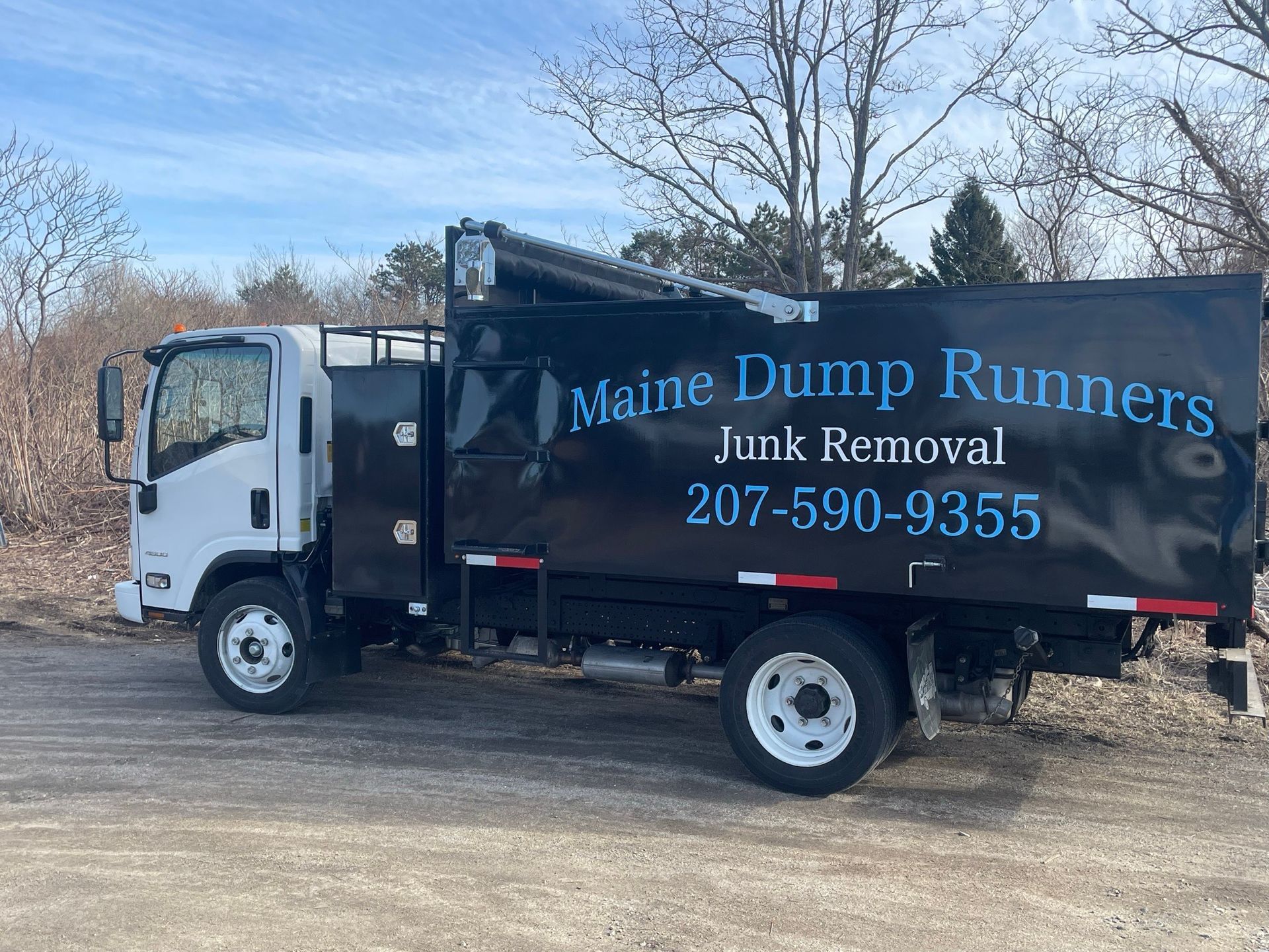 A dump truck is parked in a dirt lot.