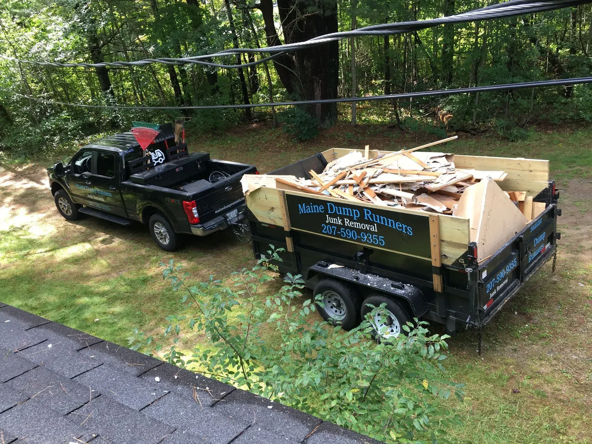 A truck is pulling a dumpster full of wood.