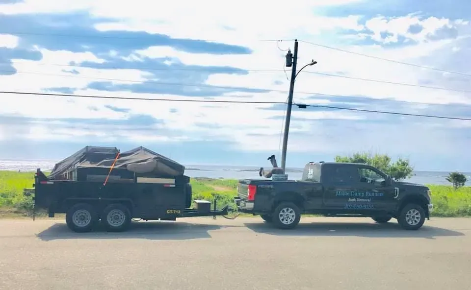 A truck is towing a trailer on the side of the road.