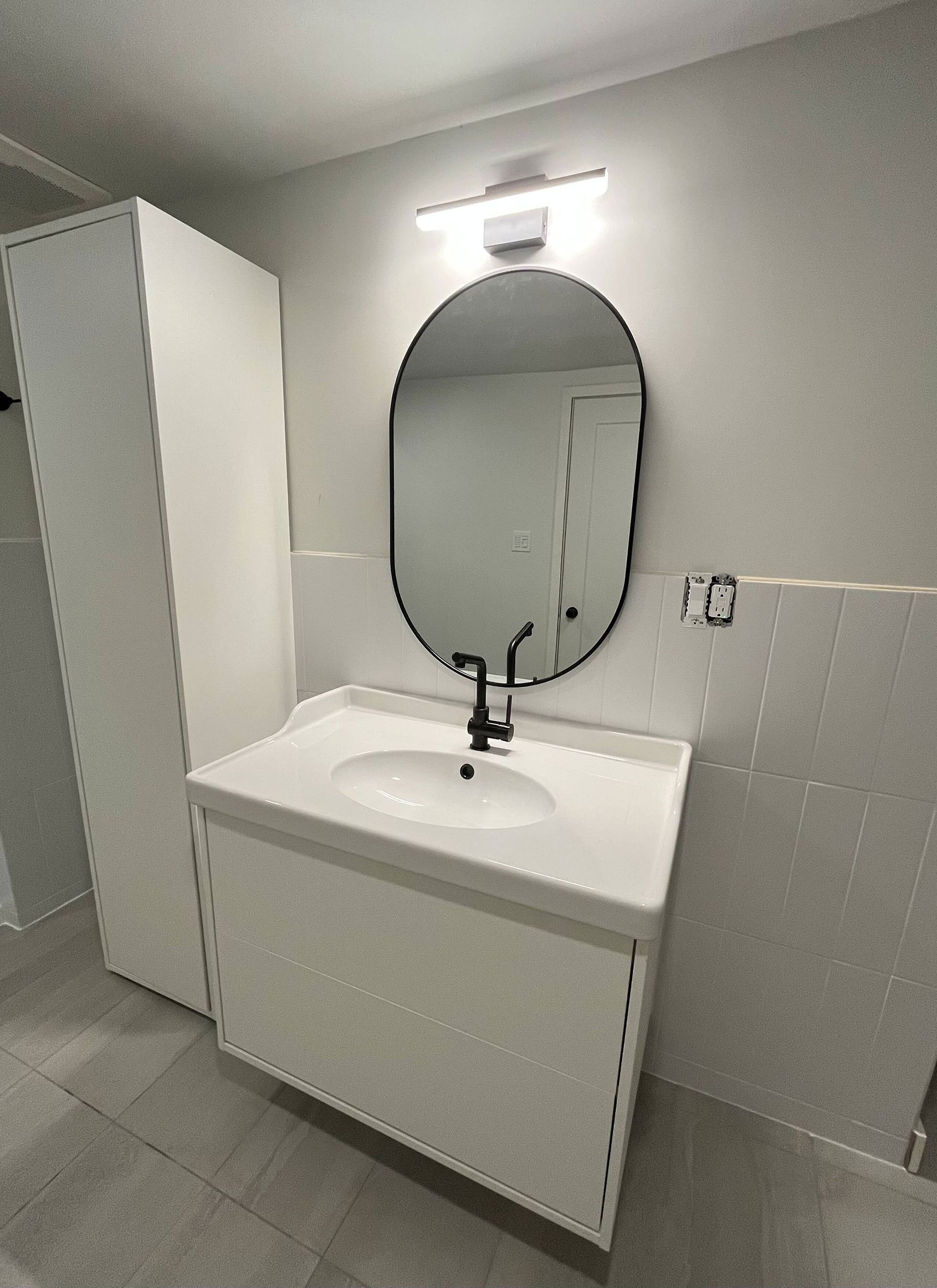 Une salle de bain avec un lavabo, un miroir et un meuble.