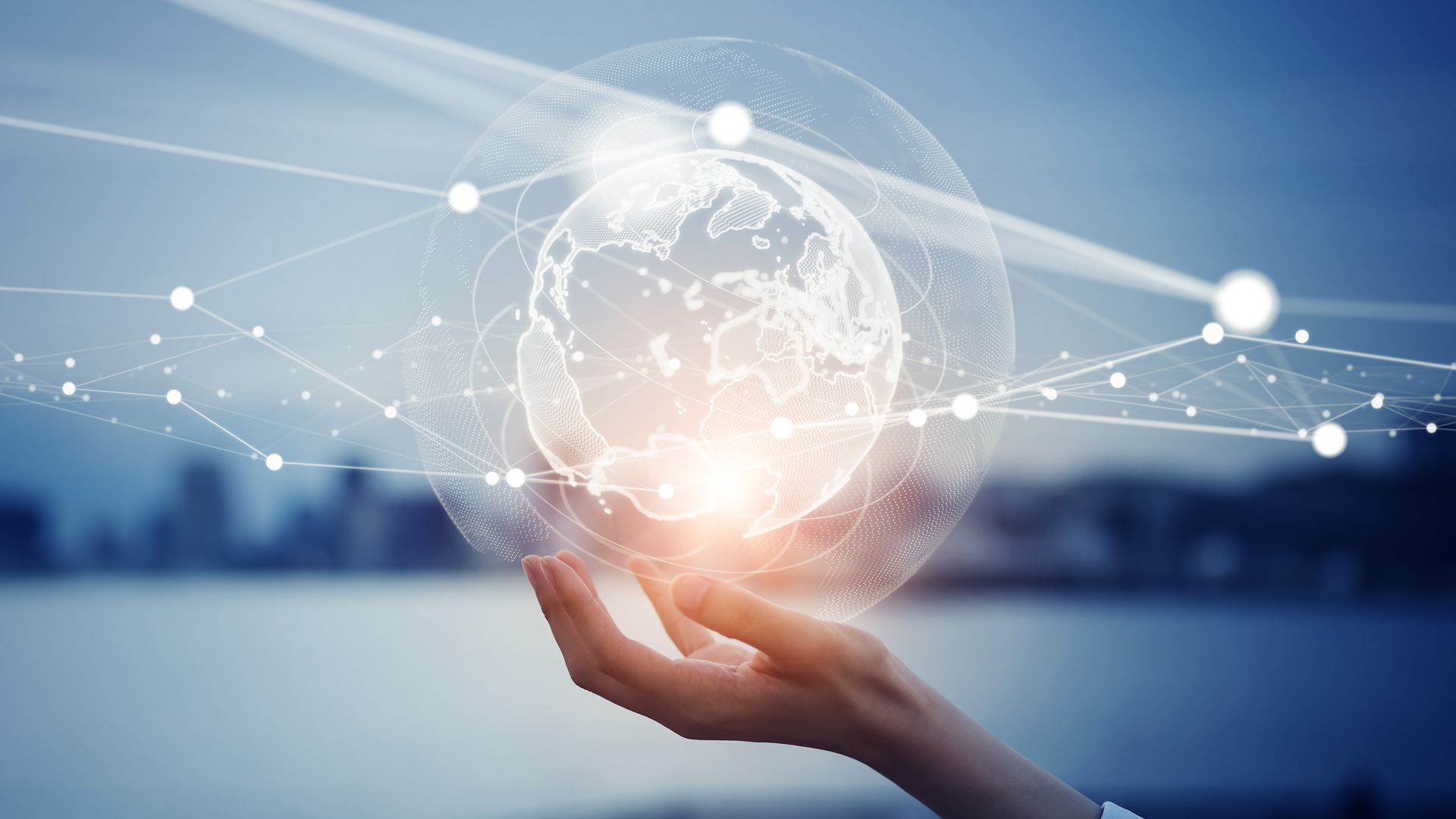 A person is holding a glowing globe in their hand.