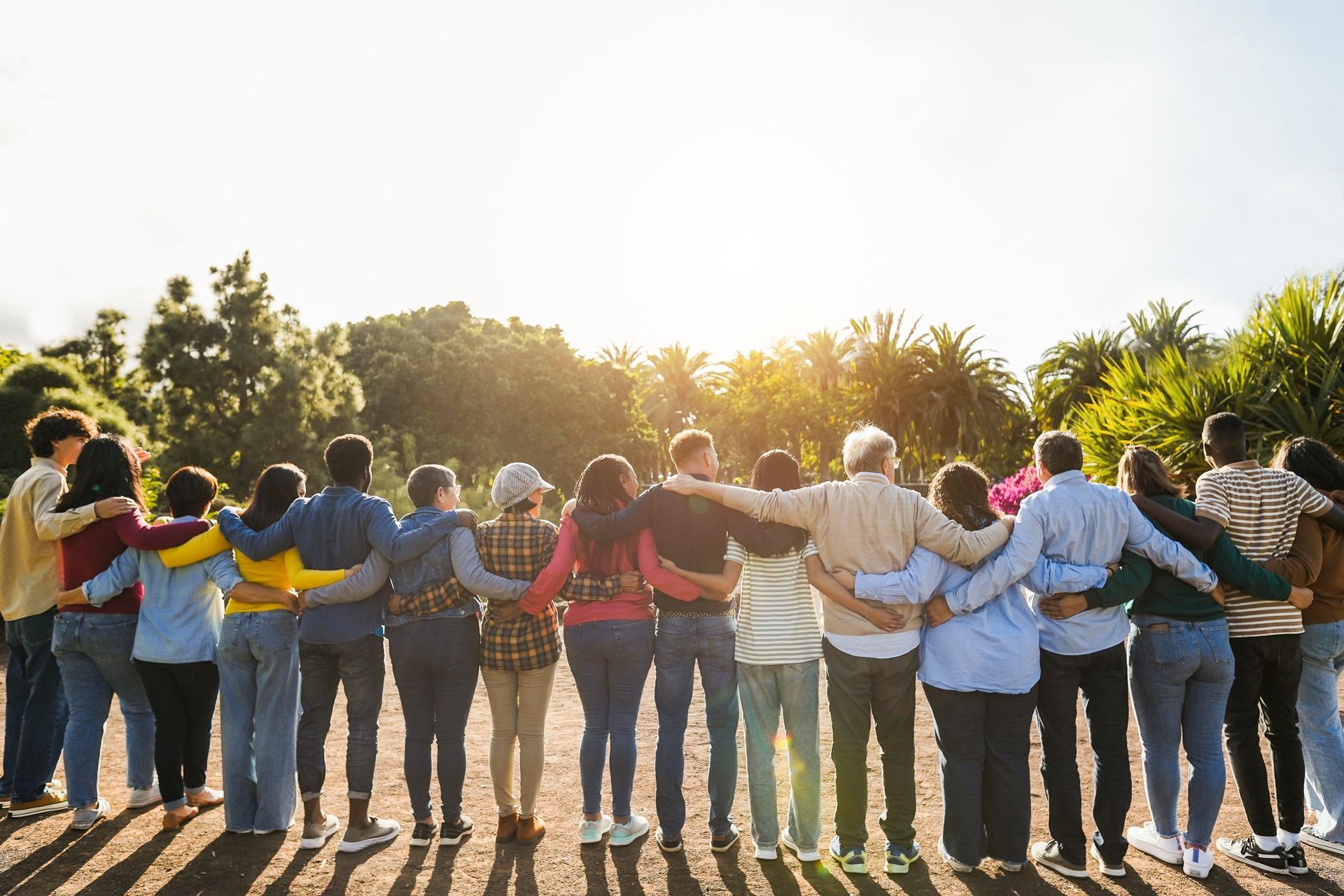 A group of people are standing in a circle with their arms around each other.