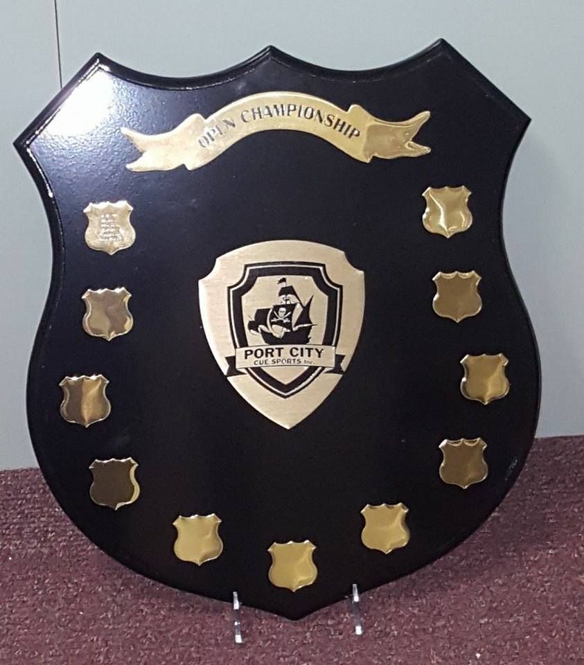 A black and gold shield that says port city on it