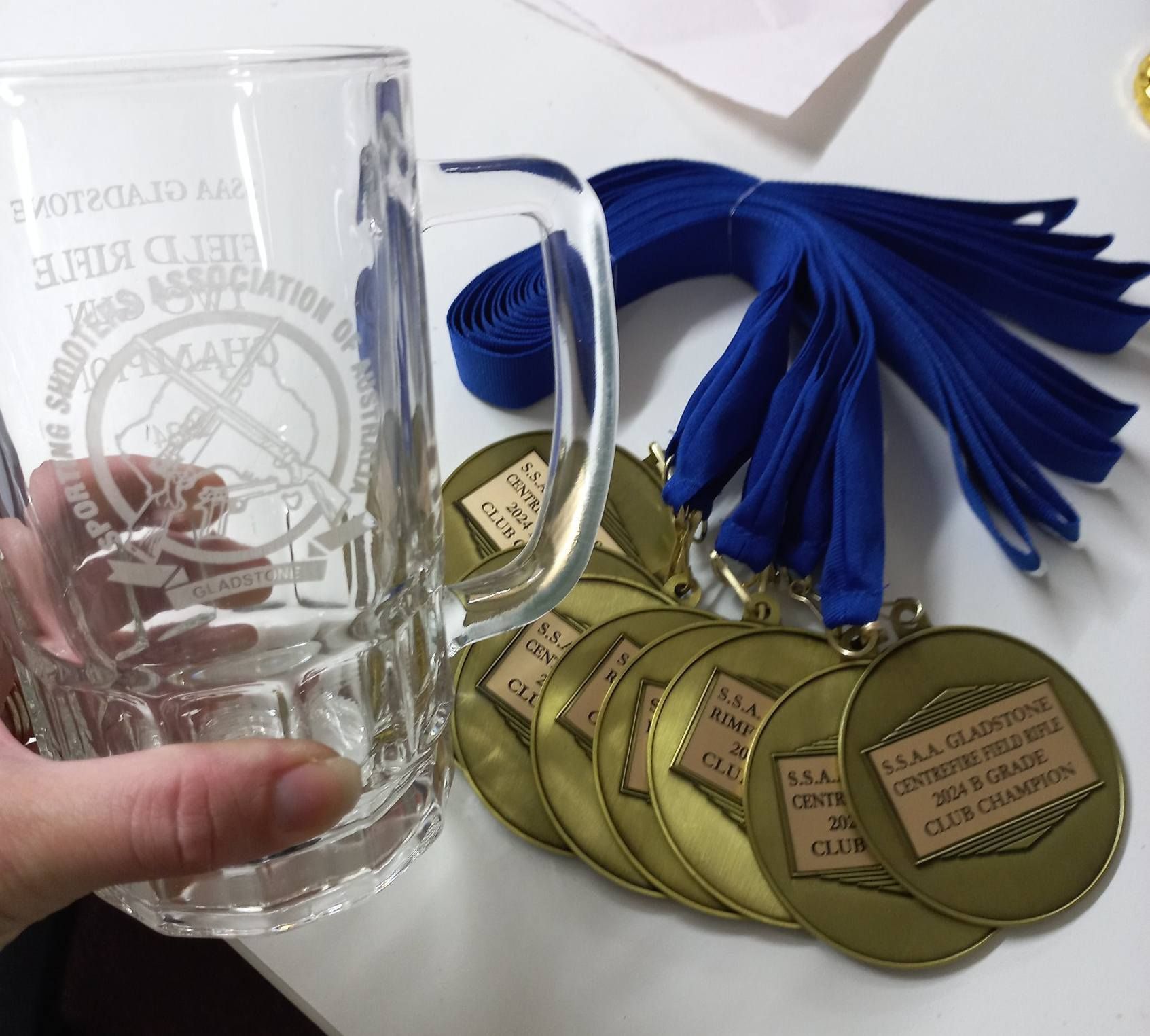 A person is holding a glass mug that says '3rd club association' on it