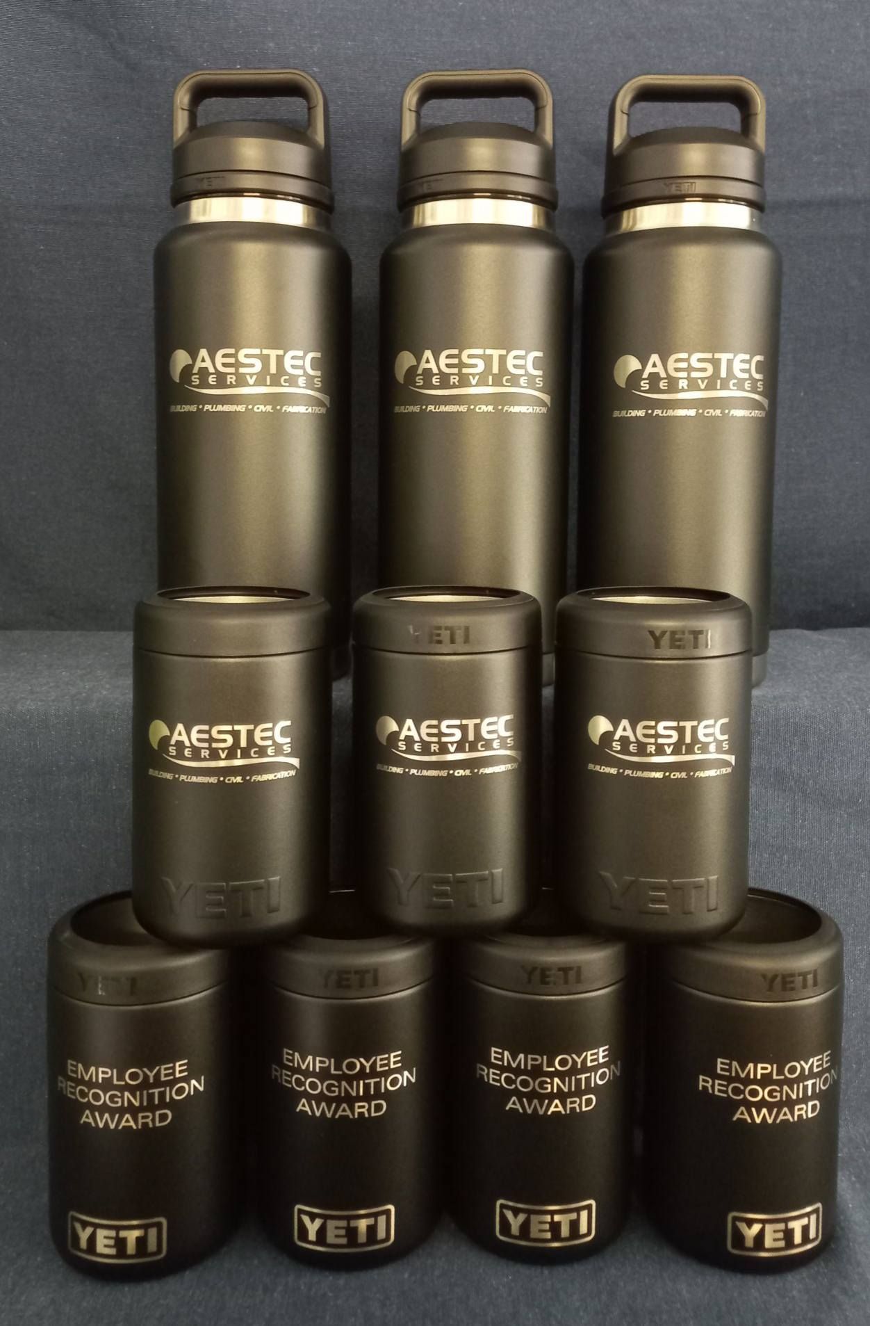 A bunch of black yeti bottles are stacked on top of each other