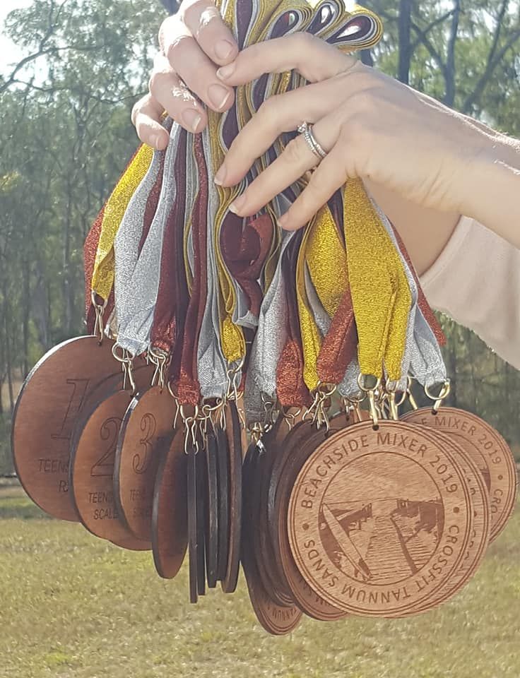 A person is holding a bunch of medals that say beachside water park