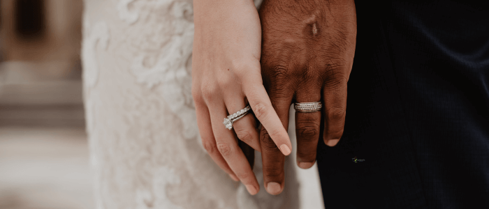 Close-up of intertwined hands, representing the bond and commitment between partners.
