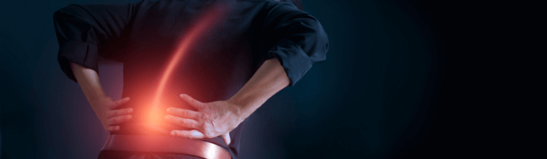 A man holding his lower back due to sharp pain in the area.