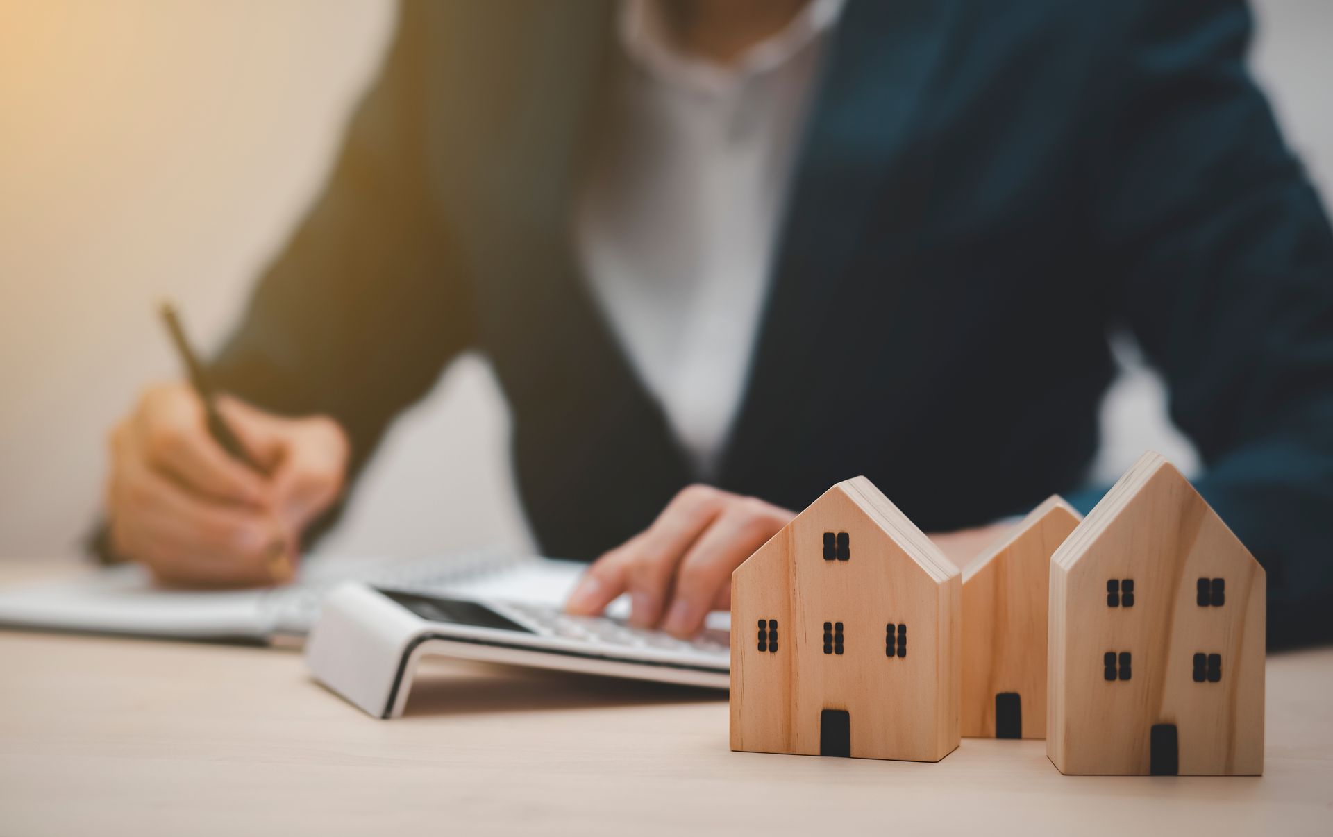 Une femme est assise à un bureau et utilise une calculatrice et un stylo.