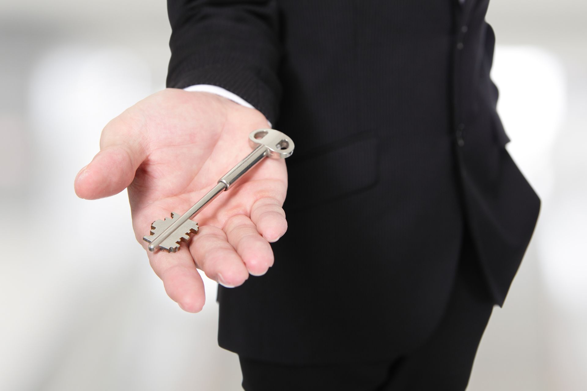 a man in a suit is holding a key in his hand