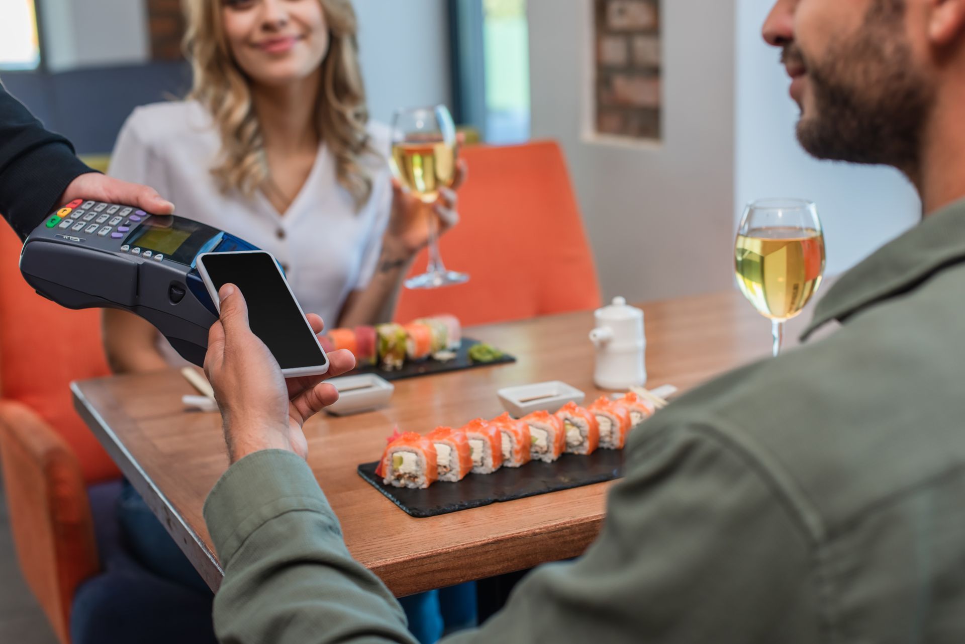 two guests are making a payment via handheld payment solution.