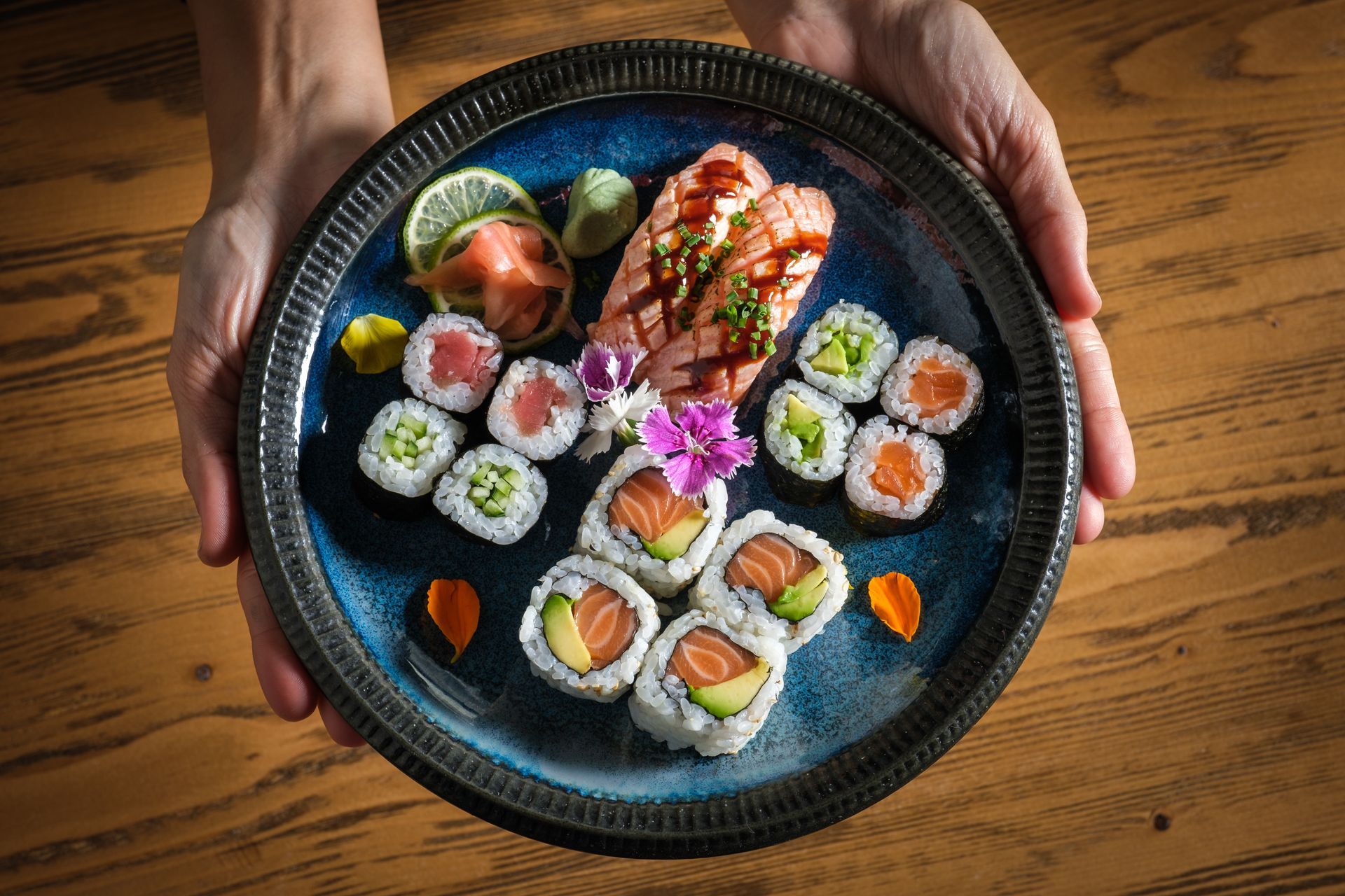 A person with plate with assorted sushi