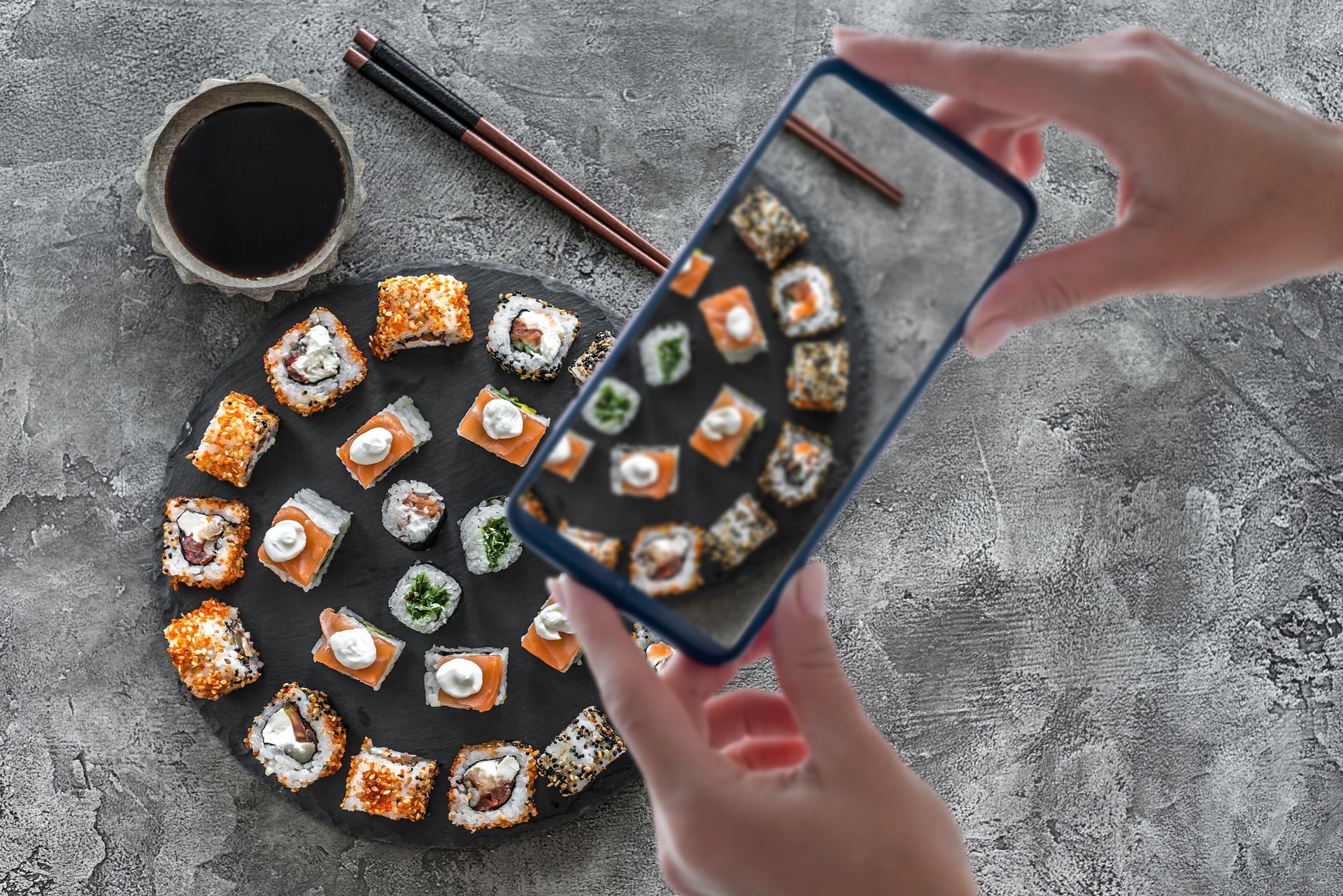 A person is taking pictures for the dishes at a sushi restaurant