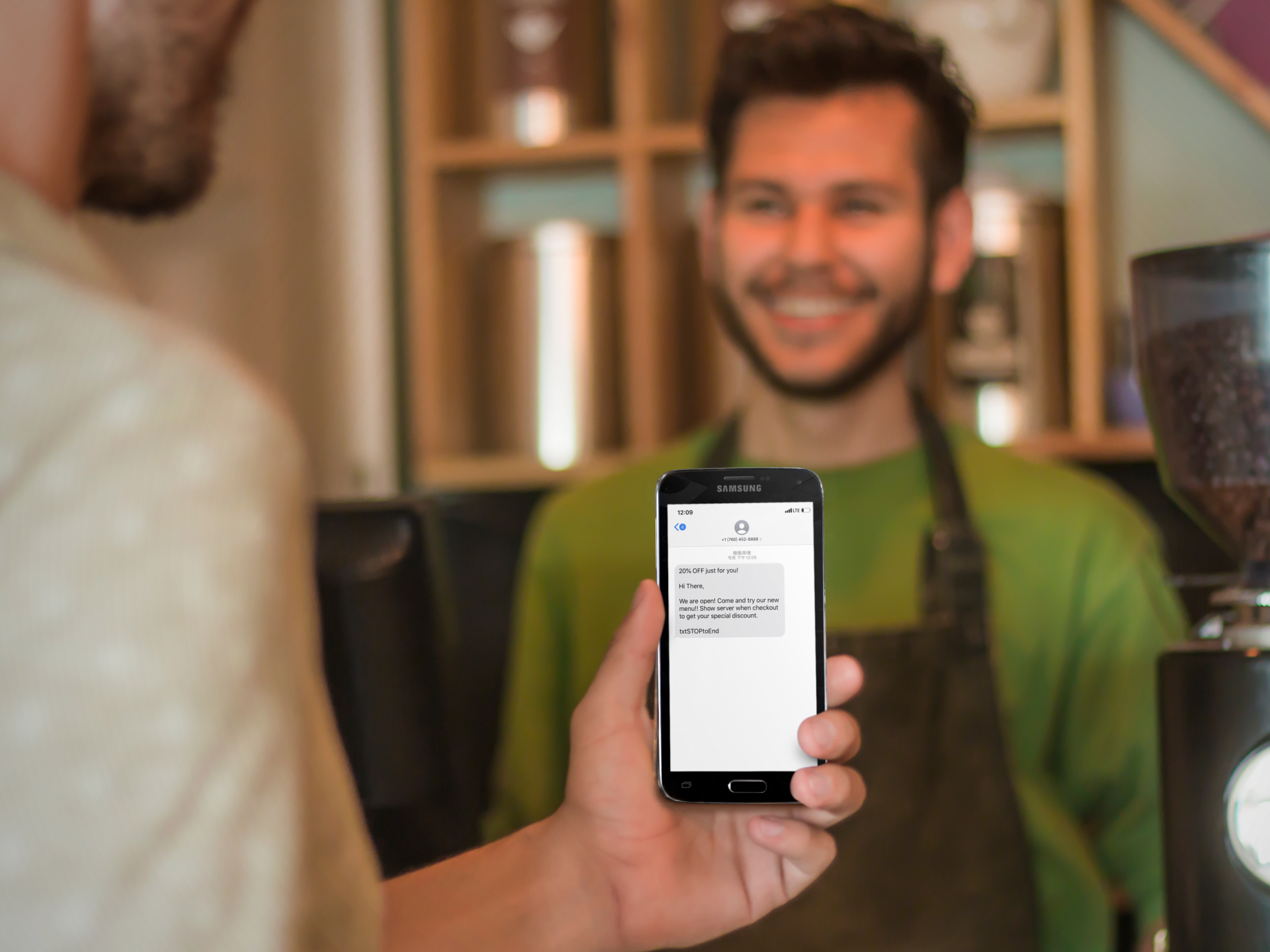 ZBS POS restaurant loyalty program marketing tools man about to show waiter sms text message coupon from phone at cafe