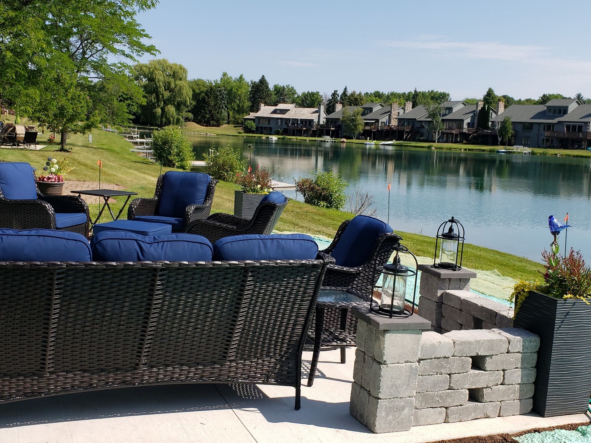 A patio with a couch and chairs overlooking a lake