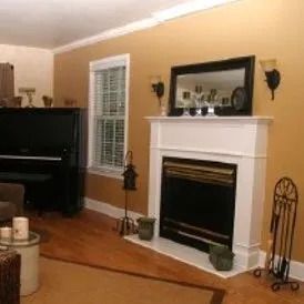 A living room with a fireplace and a piano