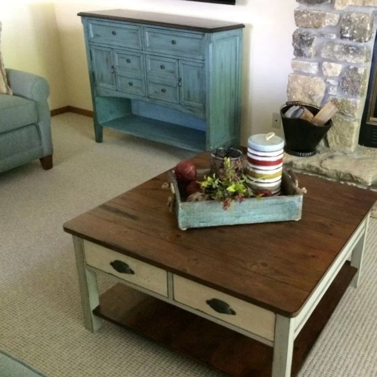 A living room with a coffee table and a blue dresser