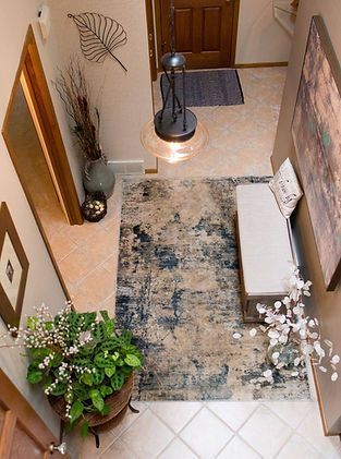 An aerial view of a hallway with a rug and a bench.