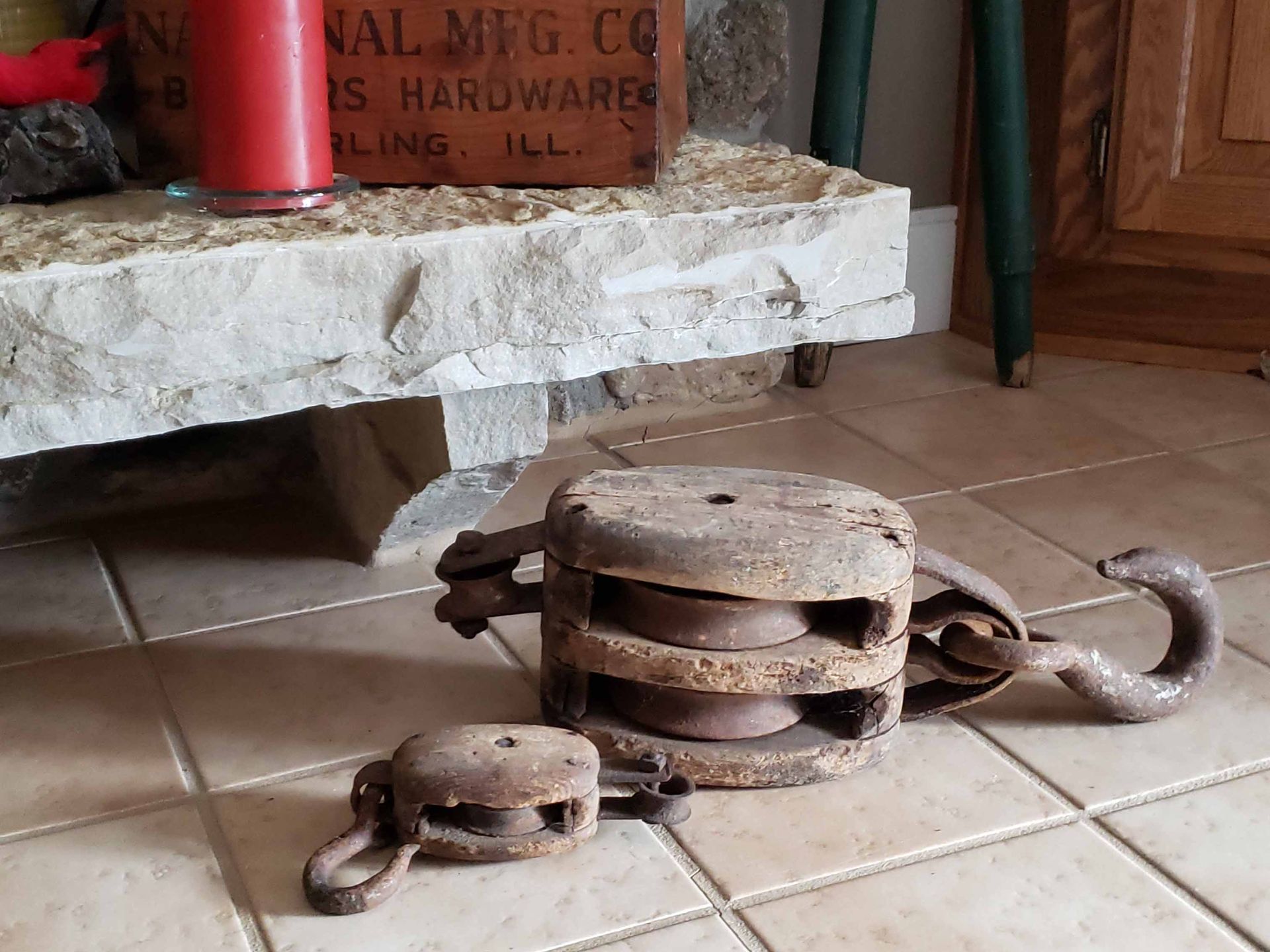A pair of pulleys are sitting on a tiled floor