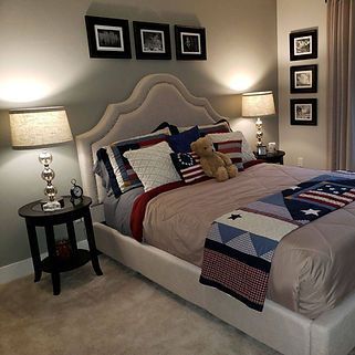 A bedroom with a large bed and a teddy bear on it