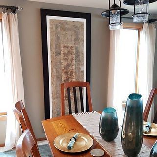 A dining room table with plates and vases on it.