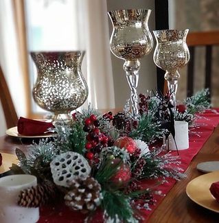 A table with a red table runner and candles on it