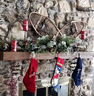 A mantle with christmas stockings and snowshoes on it