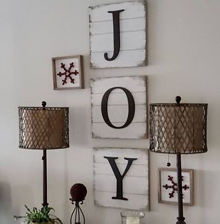 The word joy is on the wall above two lamps