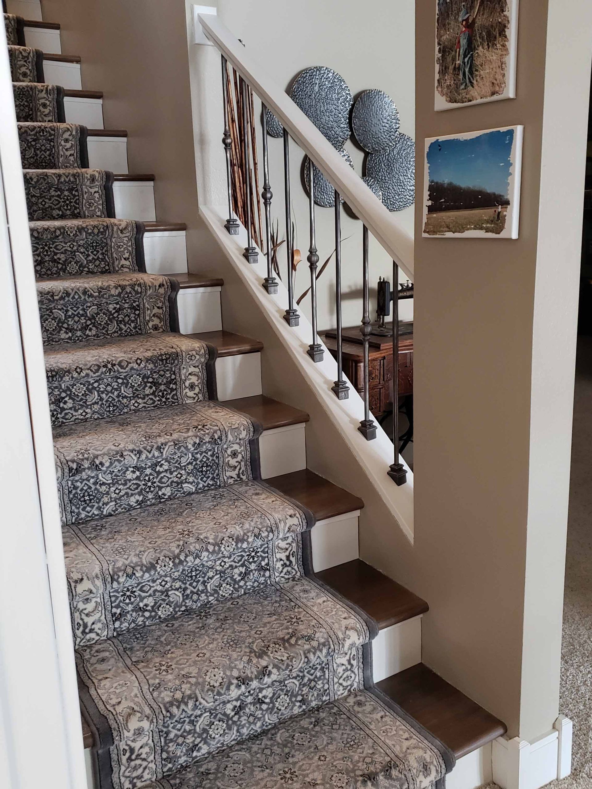 A staircase with a carpeted staircase and a metal railing