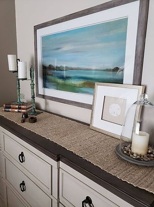 There is a painting on the wall above the dresser.