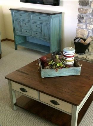 A wooden coffee table with a tray of fruit on it