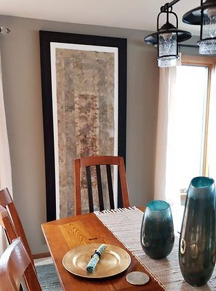 A dining room table with plates and vases on it.