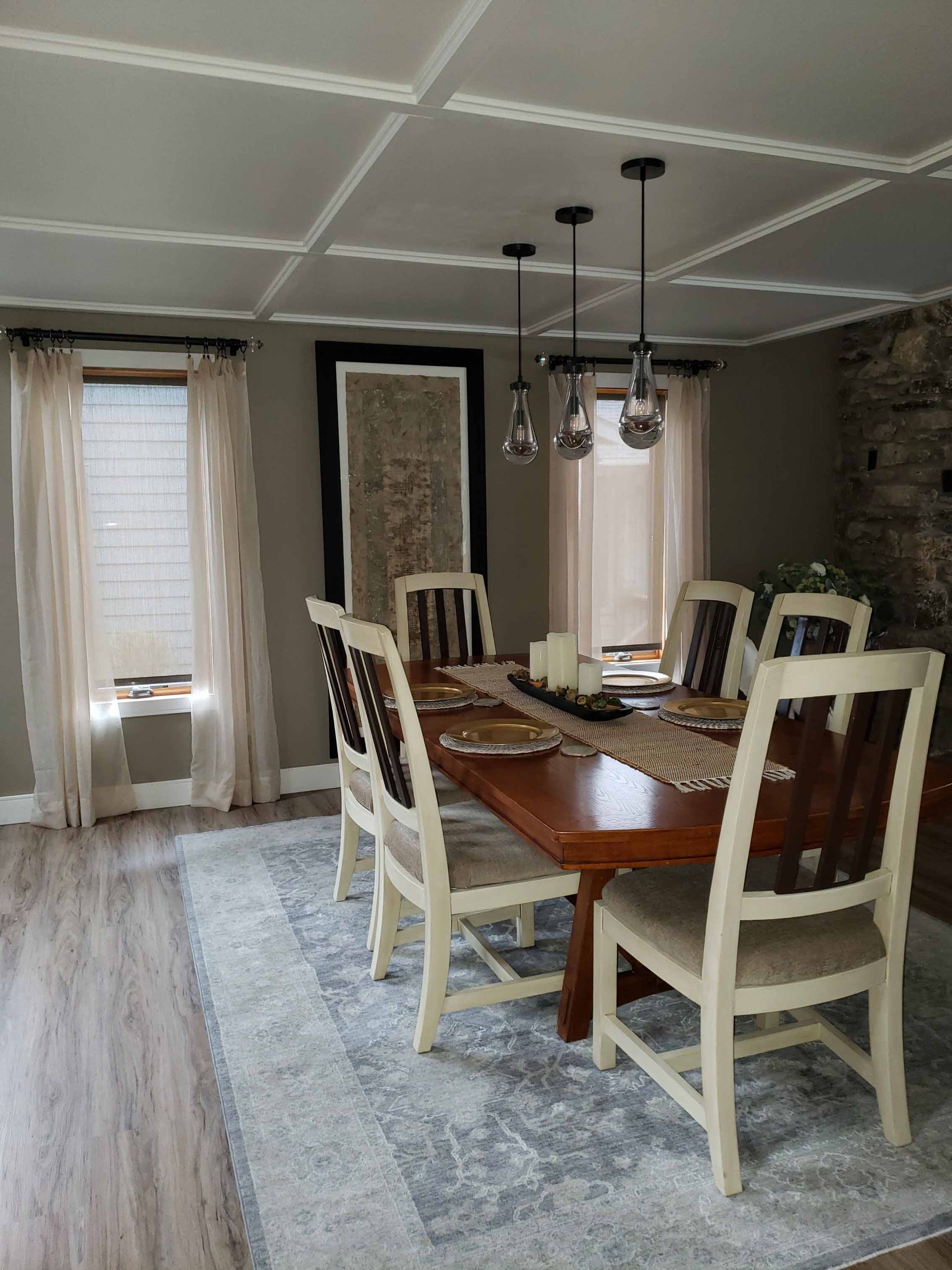 A dining room with a table and chairs and a rug.