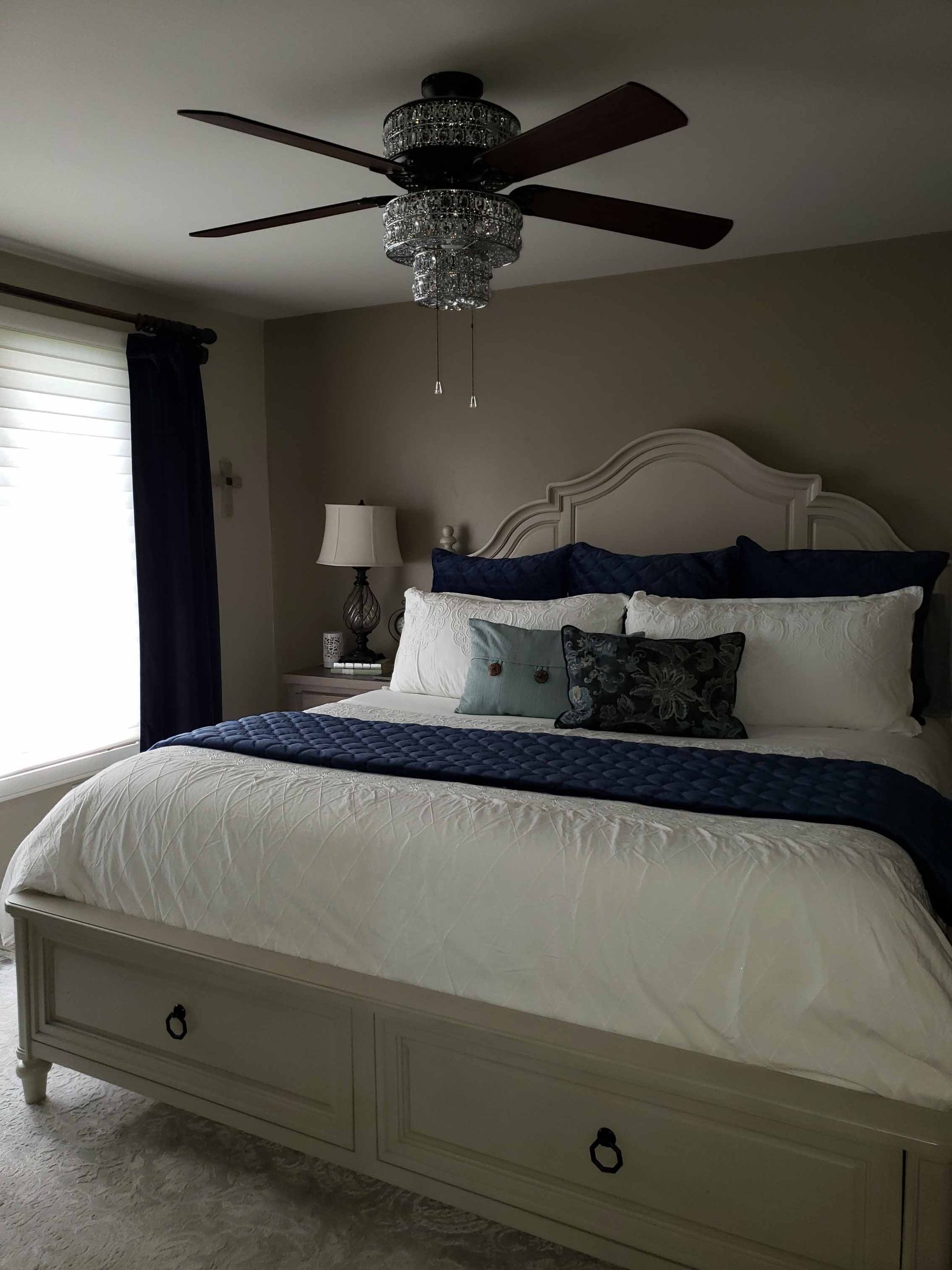 A bedroom with a large bed and a ceiling fan.