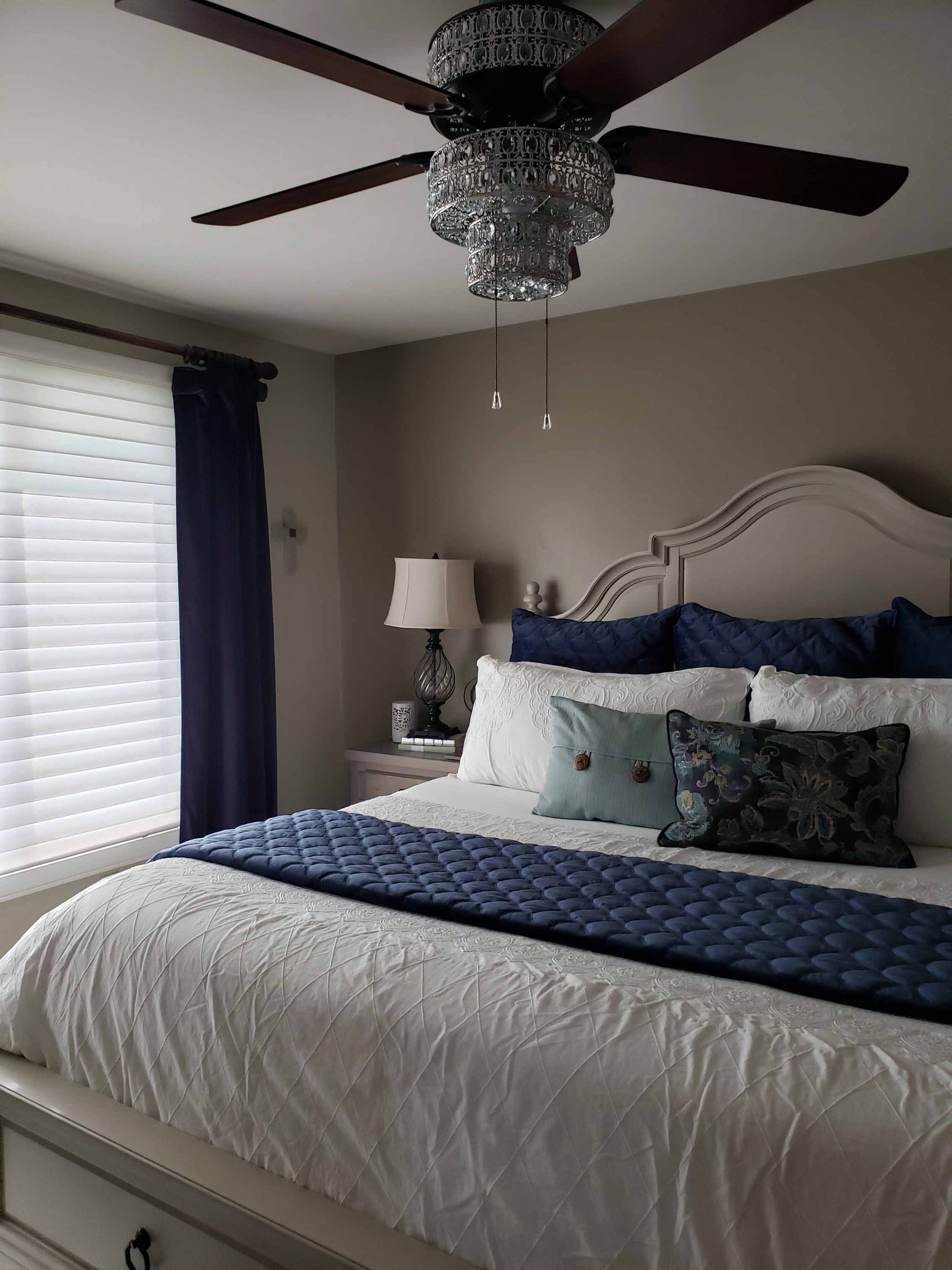 A bedroom with a bed and a ceiling fan