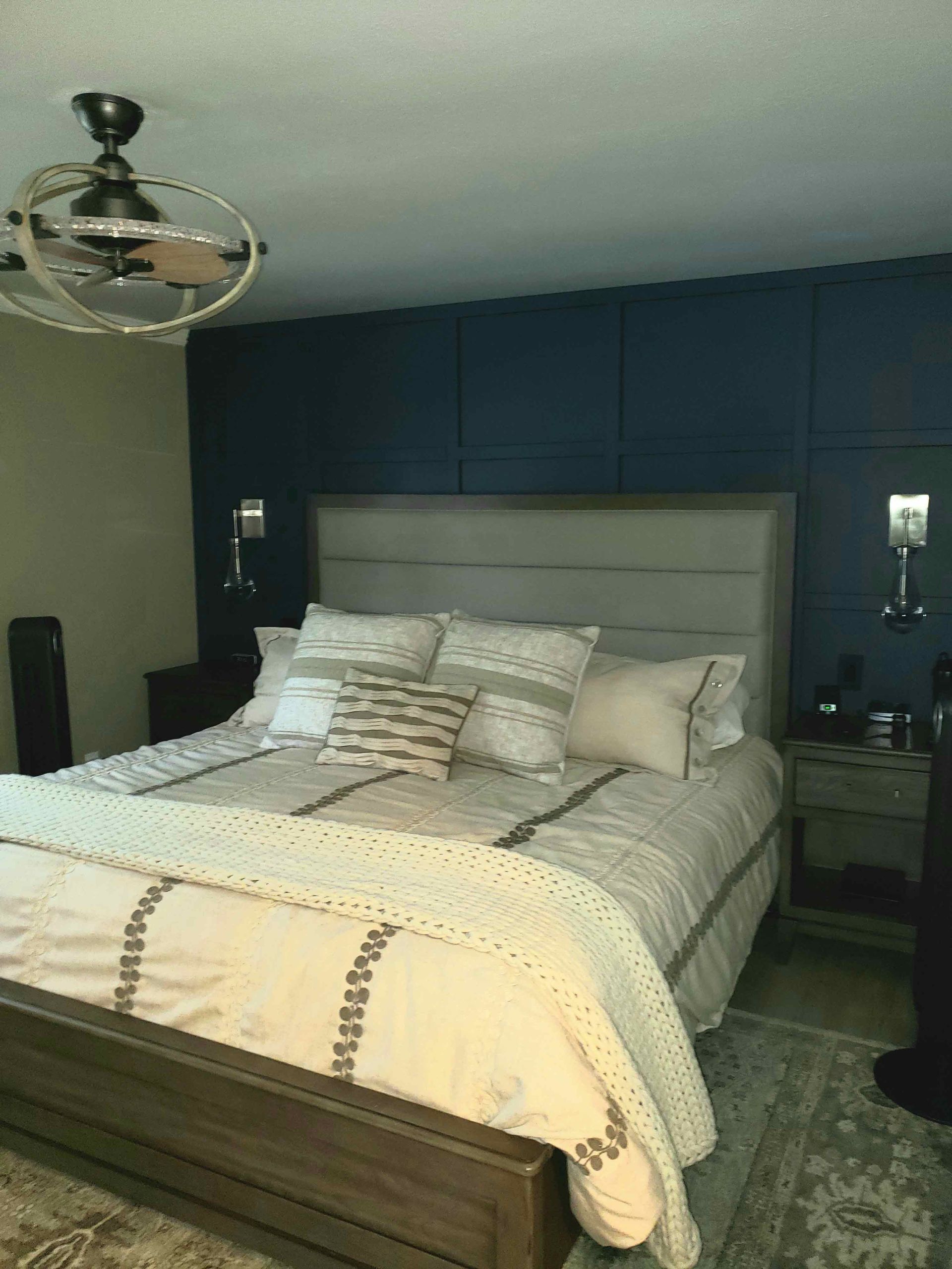 A bedroom with a large bed and a ceiling fan.