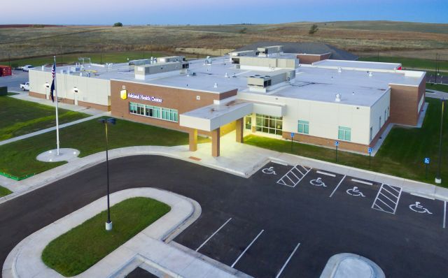 An aerial view of a large building with a parking lot in front of it.