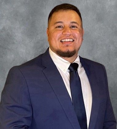 A man with a beard is wearing a suit and tie.