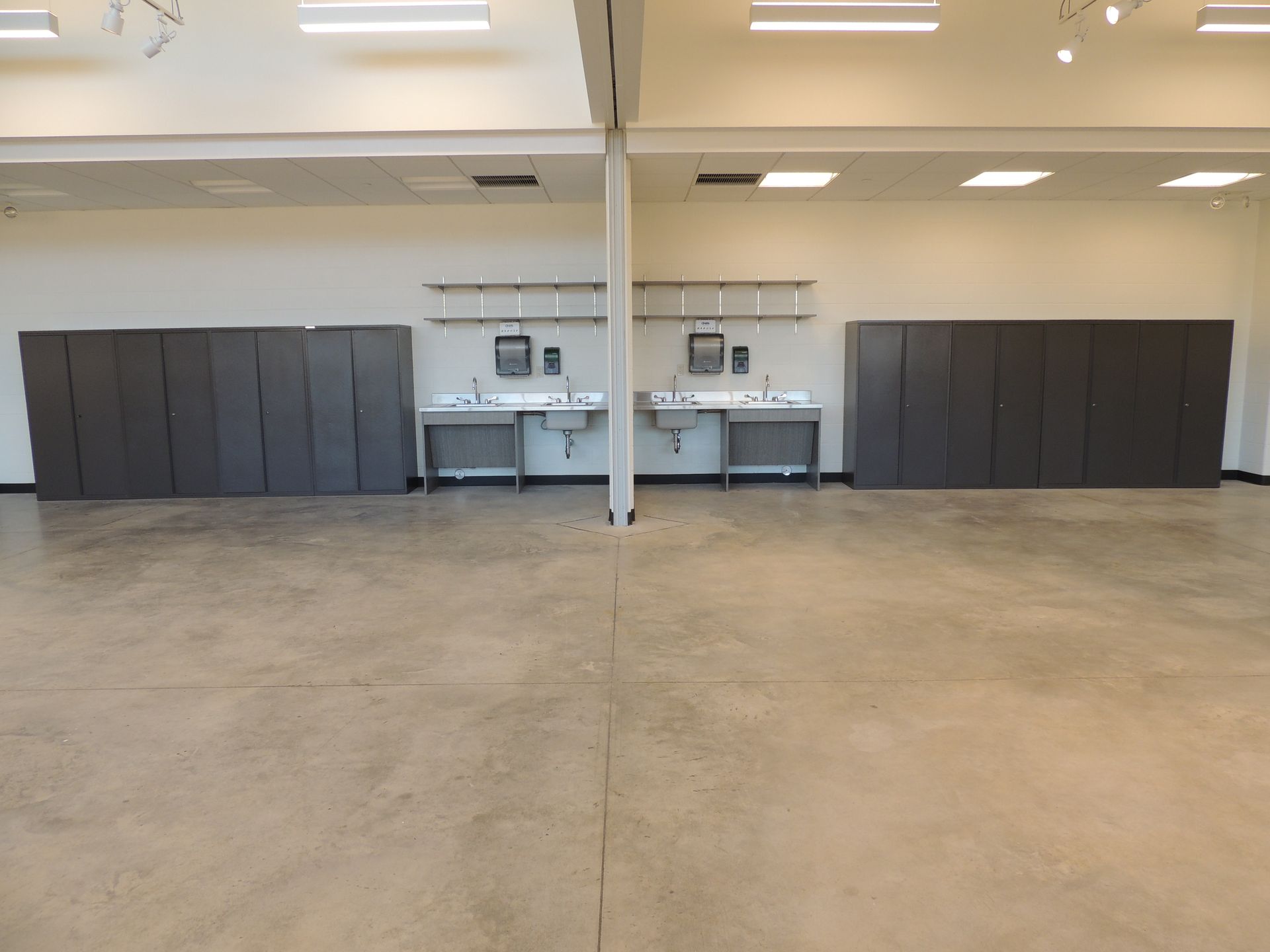 A large empty room with a lot of cabinets and sinks