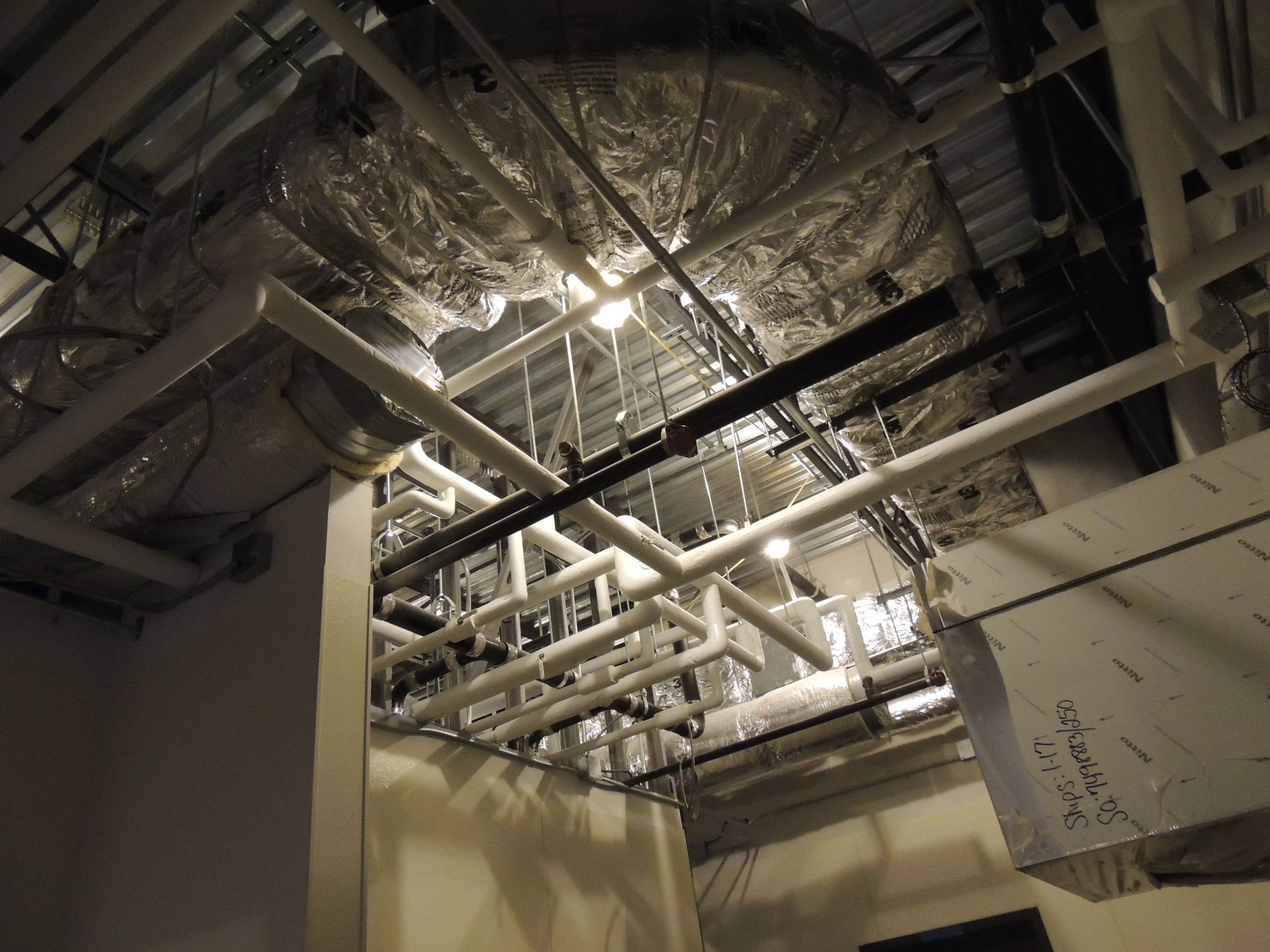 A room with a lot of pipes hanging from the ceiling